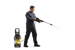 Full length profile shot of a worker in a uniform cleaning with a pressure washer machine isolated on white background