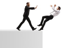 Full length profile shot of a businessman pushing a man from a wall isolated on white background