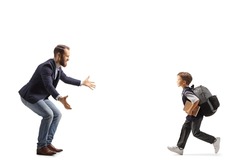Full length profile shot of a schoolboy running towards his father isolated on white background