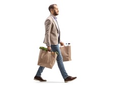 Man walking and carrying two grocery bags isolated on white background