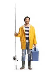 Young man in a raincoat and boots holding a fishing rod and a fridge isolated on white background