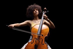 Female artist playing a cello isolated on black background