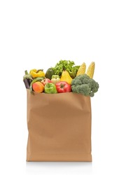 Studio shot of fresh fruits and vegetables in a paper bag isolated on white background