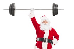 Smiling Santa holding a heavy barbell in one hand and looking at camera isolated on white background