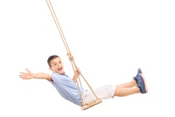 Joyful little boy swinging on a swing and gesturing happiness isolated on white background