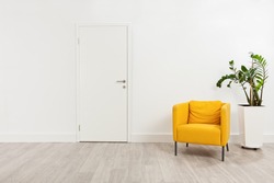 Contemporary waiting room with a yellow armchair and a plant in a white flowerpot behind it