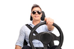Studio shot of a young man holding a steering wheel and pretending to drive isolated on white background