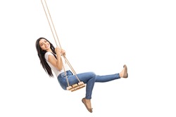 Young carefree girl swinging on a wooden swing and looking at the camera isolated on white background