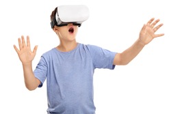Amazed little boy looking in a VR goggles and gesturing with his hands isolated on white background