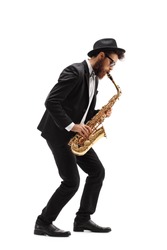 Full length profile shot of a bearded man playing a saxophone isolated on white background