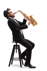 Jazz musician seated on a chair playing a saxophone isolated on white background