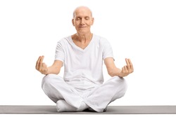Elderly man meditating on an exercise mat isolated on white background