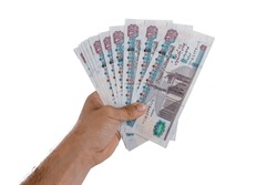 hand holding Egyptian money isolated on white background