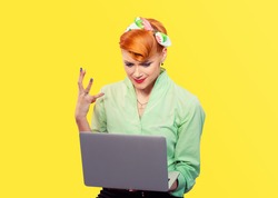 Girl frustrated with laptop. Closeup red head beautiful young woman pretty unhappy pinup girl green button shirt looking at pc retro vintage 50's 60's hairstyle Internet threat security safety problem