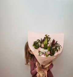 Little girl is holding Symmetrical bouquet with pink paper