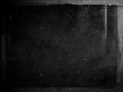 Black grunge scratched scary background with frame, distressed chalkboard, old film effect, copy space
