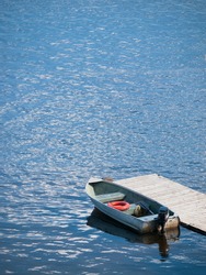 small boat waits at a wooden dock