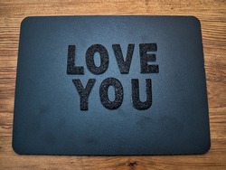 The words Love You in black letters on a black chalkboard background. Perfect for happy Valentine's Day social media posts.