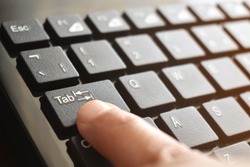 Tab button on computer keyboard with copy space on the right side.  Selective focus on the word Tab. 