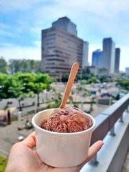 One scoop chocolate ice cream cup at balcony in the sunny day.