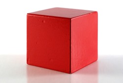 Single red cube on reflective surface. White background.