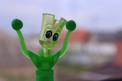 Interesting children's toy. Bright green. Against a well blurred background