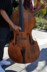 bass violin being played without a bow by a man in Washington Square park in the village in New York City 2021.