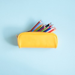 Colored different school supplies on soft  blue paper background. Back to school background. Flat lay, top view, copy space