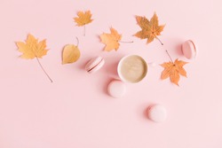 Autumn  elegant composition. Cup of coffee and dry leaves on pastel pink background. Flat lay, top view, copy space