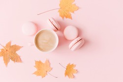 Autumn  elegant composition. Cup of coffee and dry leaves on pastel pink background. Flat lay, top view, copy space