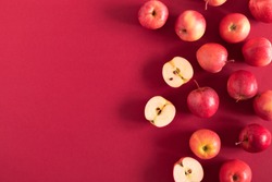 Red apples on a red background. Flat lay, top view, copy space