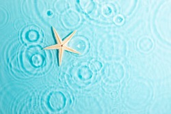 Water background. Blue water texture, surface of blue swimming pool and starfish. Spa concept background. Flat lay, top view, copy space