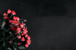 Beautiful flowers dark composition. Pink rose flowers on black stone background. Flat lay, top view, copy space