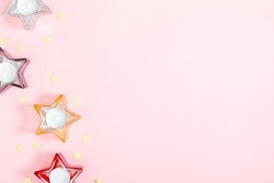 Pink festive background with stars. Candles on pink background, party. Flat lay, top view, copy space