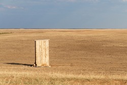 Photograph of an old rural outhouse or toilet in steppe. Single wooden building