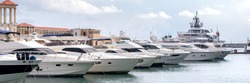 Yachts and speed boats at harbor. Power boats moored in marina. Sea coast pier. High class lifestyle. Yachting. Expensive toys. Sea transport. Journey. Expensive boats at the pier.