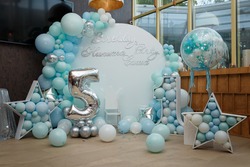 Arch of blue balloons for boy happy birthday party. Number 5 and 1 for two brothers. Festive decorative elements, photo zone with star. Inscription Nikita, Sasha.
