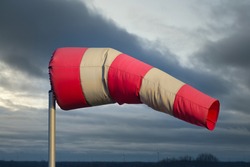 Windsock in Dutch rural landscape with heavy wind and stormy sky