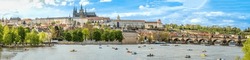 A panoramic view of Prague, the capital of the Czech Republic. View of Prague Castle and Charles Bridge. Summer time, people swim on catamarans. banner