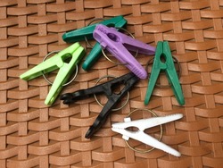 Colorful hanger clips laying on background bamboo motif plastic.