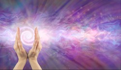 Channelling Vortex healing energy  - female hands facing upwards with a white spiralling vortex energy formation and pink blue purple misty ethereal energy field background with copy space 