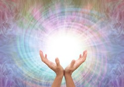 Channeling healing energy vortex spiral - female cupped hands reaching up into a white vortex energy against a multicoloured  spiralling light background with copy space
