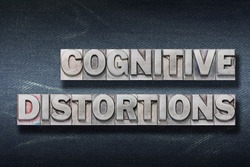 cognitive distortions phrase made from metallic letterpress on dark jeans background