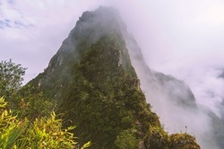 famous Huayna Picchu mountain with ascending tourists by foggy morning in Peru 