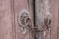 Old doorknob, knocker chained door in Cumalikizik, Bursa, Turkiye. Chain, lock. Chained, locked.