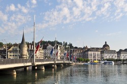 Morning stroll around the Reuss river bank at Lucerne, Switzerland, while overlooking the Lucerne bridge towards the city buildings at the distance.