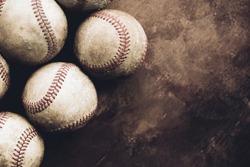 Rough and rugged texture of old baseball balls close up on brown vintage background, copy space for sport.