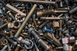 A bunch of bolts, nuts, screws, washers, and other metal junk from a garage or car or appliance repair shop. 