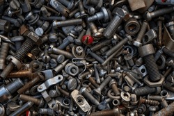 A bunch of bolts, nuts, screws, washers, and other metal junk from a garage or car or appliance repair shop. 