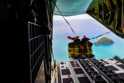 Military transport aircraft C-130, opened its doors to the rear. The process of releasing the baggage, the training of military aid, rescue at sea.
